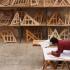 Un apprenti travaille sur son atelier devant une étagère pleine de création en bois